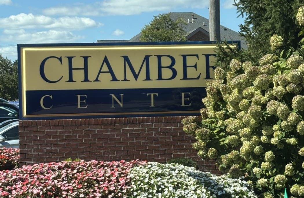 Close view of the blue and gold Chamber Center entrance sign.